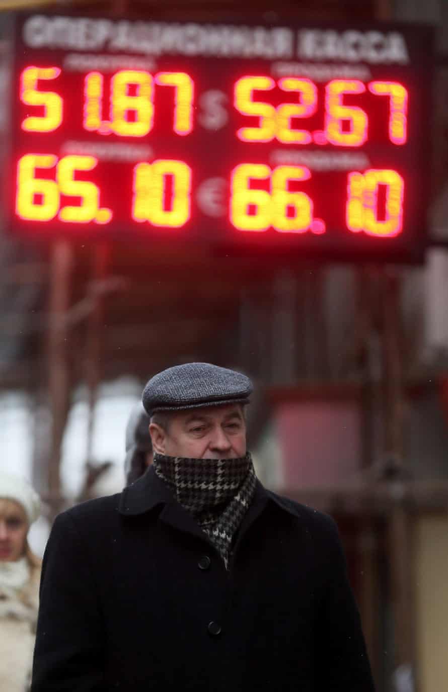 A Russian man passes electronic information panels displaying currency exchange rates in Moscow, Russia, 01 December 2014.