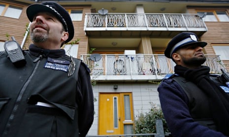 Police stand guard at a property in Brixton