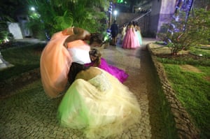 Girls help each other with their dresses while waiting to enter the venue