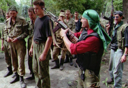 A Chechen fighter points his rifle to the head of a Russian prisoner of war outside Grozny in August 1996.