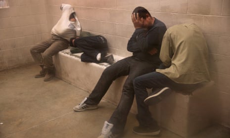 Migrants without papers sit in a holding cell at the US Border Patrol detainee processing center n McAllen.