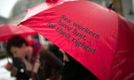 A woman holds a red umbrella – seen as a symbol of sex workers' rights.