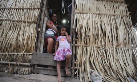 Arara Indians look out from the door of their home in the region where Belo Sun Mining Corp. of Canada has obtained a license to take over all gold mining operations from local wildcat miners, near the river bend known as Volta Grande which will be largely exposed by the ongoing construction of the Belo Monte hydroelectric dam, near Altamira October 4, 2012. Brazil's Federal Prosecutor's Office has opened an investigation into Belo Sun's gold project and its impact on the environment and the Amazon tribes in the region, according to Federal Prosecutor Thais Santi in a press release last September.
