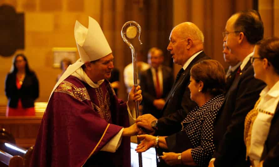 Archbishop of Sydney, Most Reverend Anthony Fisher shakes hands with Australian Governor General Peter Cosgrove during a mass to pay respect to the victims of the Martin Place siege.