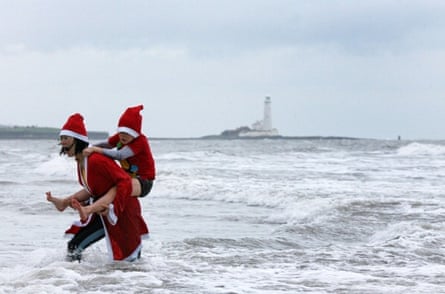 Swimmers in fancy dress brave the cold in the North Sea at the annual New Year's Day sea swim in Whitley Bay, northeast England on January 1, 2014. AFP PHOTO/ LINDSEY PARNABY.        (Photo credit should read LINDSEY PARNABY/AFP/Getty Images)