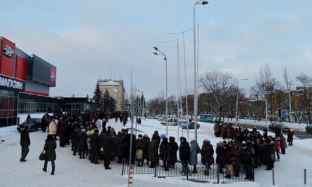 People wait for monthly humanitarian aid packages in front of the Donbass hockey stadium in Donetsk.