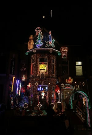People look at Christmas lights on a house in the Newton Heath area of Manchester.