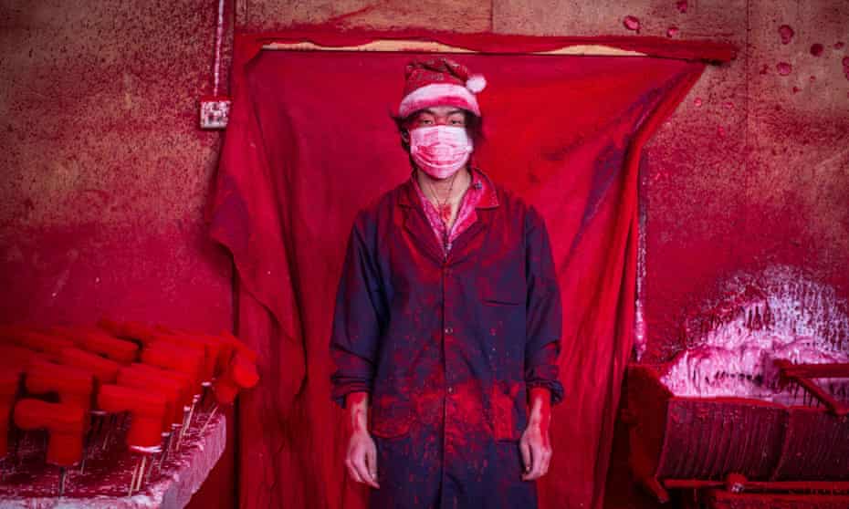 Santa's workshop … 19-year-old Wei works in a factory in Yiwu, China, coating polystyrene snowflakes with red powder.