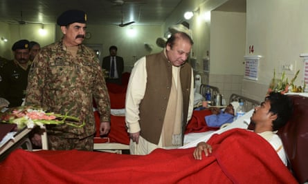 Prime Minister Nawaz Sharif, talks to a student injured in Tuesday's school attack, accompanied by Army Chief General Raheel Sharif.