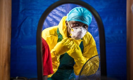 A healthcare worker dons protective gear before entering an Ebola treatment centre in Freetown, Sierra Leone.