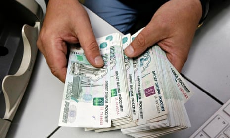 An employee counts Russian rouble banknotes at a private company's office in Krasnoyarsk