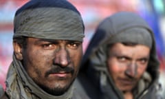 Afghan labourers pause as they work at a charcoal shop on the outskirts of Kabul.