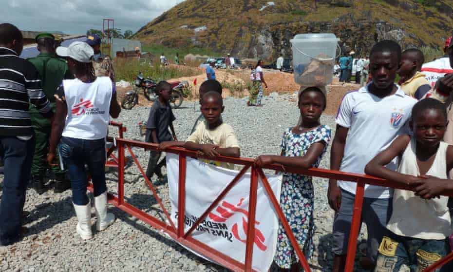 Children stand outside a an MSF centre financed by France to treat Ebola patients in Macenta, Guinea.