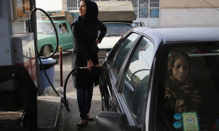 A woman fills her car with petrol in Shahinshahr, Iran.