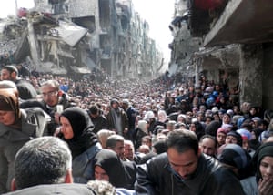 Residents of the besieged Palestinian camp of Yarmouk queue