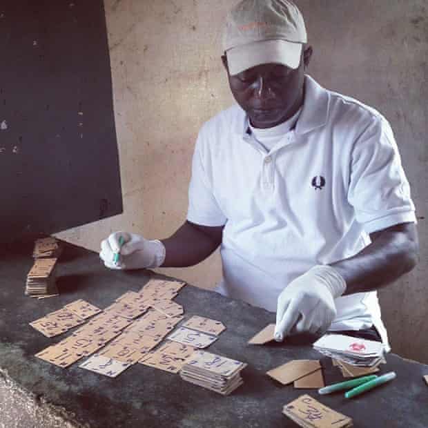Arthur Johnson, a security guard at the outpatient department at Redemption Hospital draws up cards for patients with a blue marker. #Liberia #Ebola #Eboladiaries