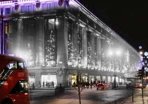 Selfridges on Oxford Street is lit up by Christmas decorations and festive splendour in 1935, a street now bustling with traffic including brand-new doubledecker buses