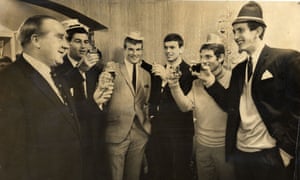 Leyton Orient Chairman Arthur Page, left, and the Orient players, including Cliff Holton, 2nd left, enjoy a  drink at the club's 1966 Christmas shindig