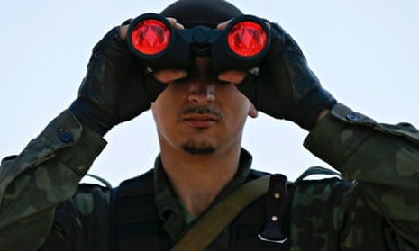 A pro-Russian separatist looks through binoculars