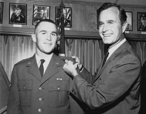 As a congressman in 1968, Bush pins bars on his son George W’s uniform, representing his entry into the Texas air national guard as a 2nd lieutenant.