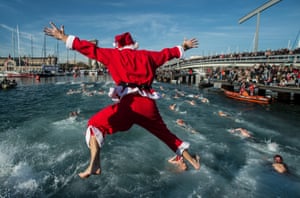 A competitor dressed as Santa Claus  jumps into the sea during the 105th Barcelona Traditional Christmas Swimming Cup at the Old Harbou