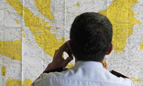 An airport official checks a map of Indonesia at the crisis center set up for the missing AirAsia flight QZ8501.