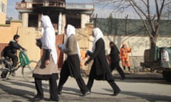 epa04509208 People pass by the office of a charity a day after an attack by Taliban militants, in Kabul, afghan women