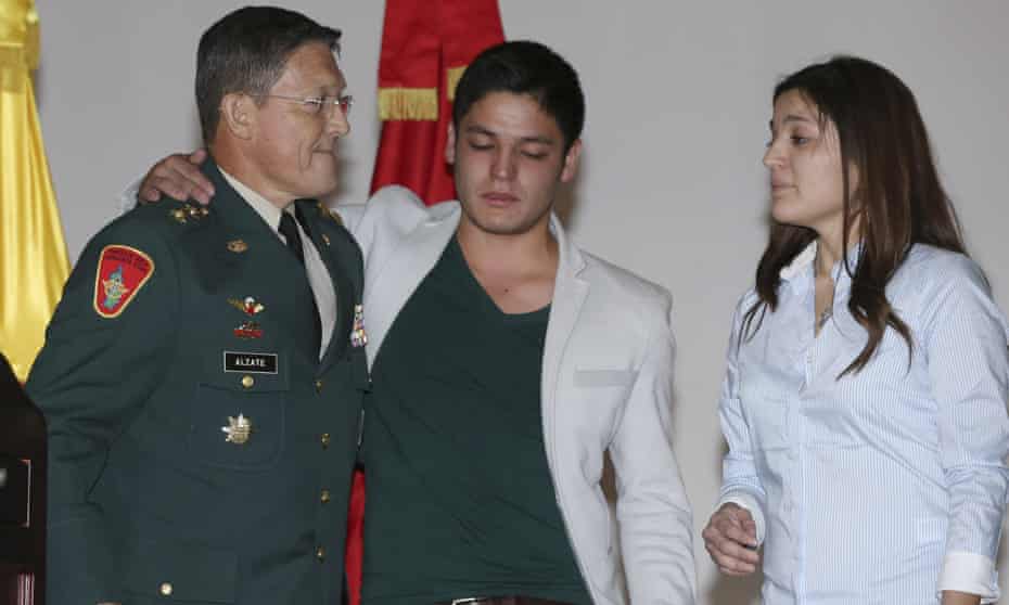 General Ruben Alzate, left, embraces his son Juan Pablo after reading a statement at the military hospital in Bogota on Monday.