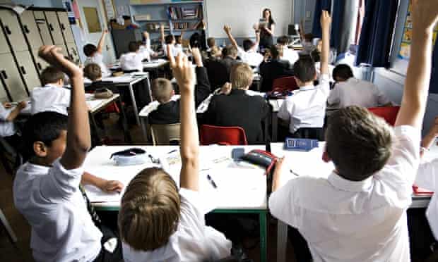 Schoolchildren holding their hands up