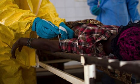 Medical staff take a blood sample from a suspected Ebola patient in Sierra Leone