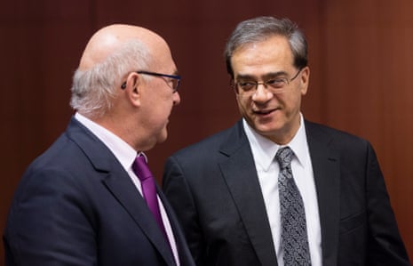 French Finance & Public Accounts Minister Michel Sapin (L) is talking with the Greek Finance Minister Gikas Hardouvelis (R) prior a meeting of the eurogroup finance ministers at the EU Council building.