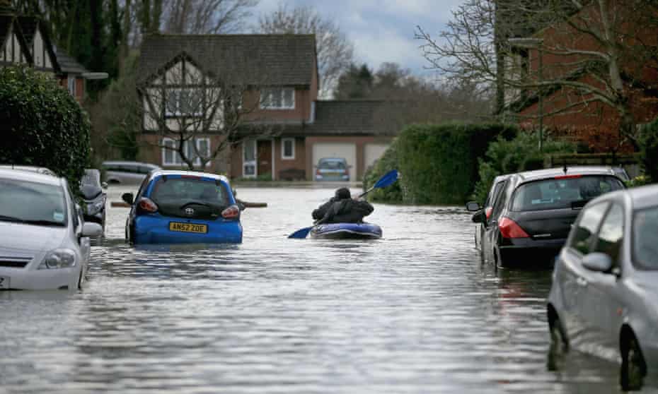 Residents use a boat make their way through floodwater that has cut off their homes on February 11, 2014 in Chertsey.