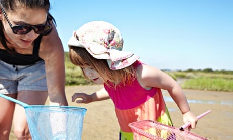 Mother and daughter fishing with nets on a beach