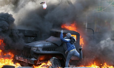 A protester throws a device at riot police.