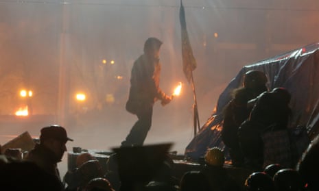An anti-government protester prepares to throw a molotov cocktail in the centre of Kiev.