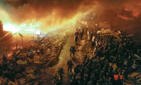 Ukrainian riot police stand in front of the fire ring around of the Independence Square.