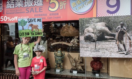 Two girls protest in front of a shop selling ivory in Hong Kong