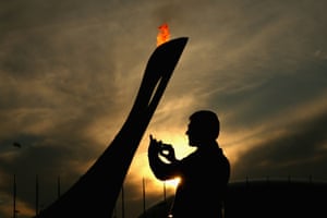 A spectator takes a photo near the Olympic cauldron.