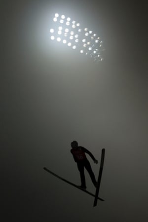 Japan's ski jumper Yuta Watase soars through heavy fog.