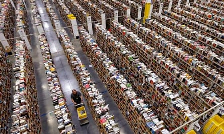 An Amazon.com employee walks down one of the miles of isles at an Amazon.com Fulfillment Center