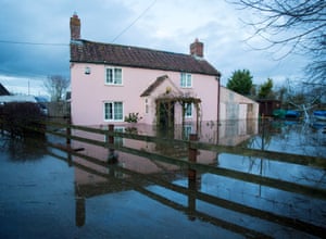 A pink house is reflected in the flood waters.