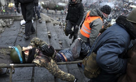 Protesters evacuate a wounded demonstrator from Kiev's Independence square after the security forces were pushed back in new clashes.