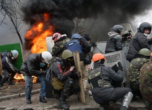 Anti-government protesters try to shelter behind their shields during clashes with police in the center of Kiev.