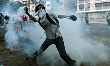 A student protester throws back a teargas canister during demonstrations in Caracas