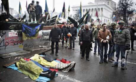 Bodies lay on the ground surrounded by fellow anti-government protesters during clashes in Kiev
