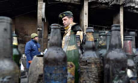 A man walks past empty Molotov cocktail bottles on Kiev's Independence Square.