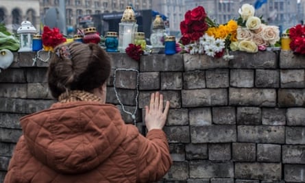 A woman pays her respects at a memorial to anti-government protesters in Kiev, Ukraine