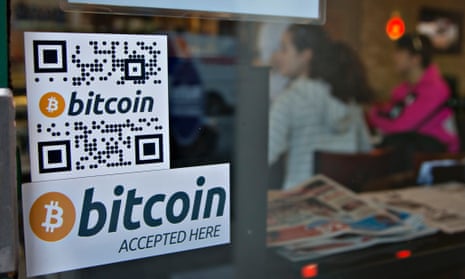 Signs on a window advertise a bitcoin ATM machine that has been installed in a cofee shop.
