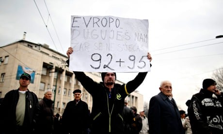 A protester in Sarajevo holds a placard reading: "Europe, you owe us, do you remember 1992-1995?"