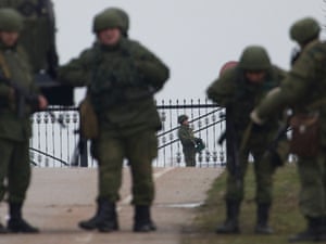 Unidentified gunmen wearing camouflage uniforms guard the entrance to the military airport at the Black Sea port of Sevastopol in Crimea, Ukraine, Friday, Feb. 28, 2014.